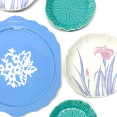 four plates with flowers painted on them are arranged in the shape of snowflakes