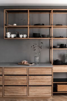 a wooden shelf with dishes and cups on it