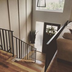 the stairs lead up to an upstairs living room with potted plants on either side