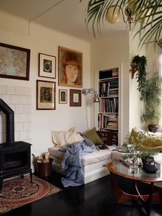 a living room filled with furniture next to a fire place and bookshelf on the wall