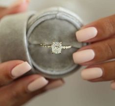 a woman holding an engagement ring in her hand