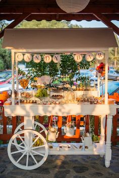 an outdoor food cart is set up for a party with decorations and flowers on it