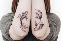 two fish tattoos on both arms, one is black and the other has white ink