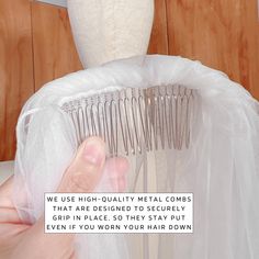 a person holding a hair comb in front of a dress on a mannequin