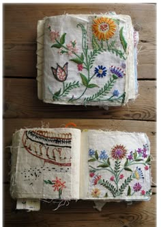 an open book with embroidered flowers and butterflies on it, sitting on a wooden surface