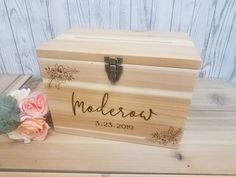 a wooden box with the name nadderos on it and flowers next to it