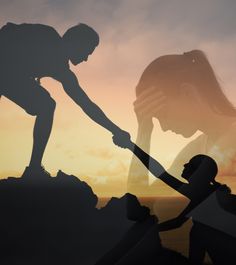 a woman holding the hand of a man on top of a hill with sunset in background