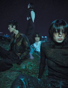 four people sitting on the ground at night