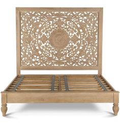 a wooden bed frame with intricate carvings on the headboard