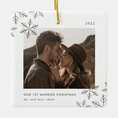 a christmas ornament with a photo of a man and woman in the snow