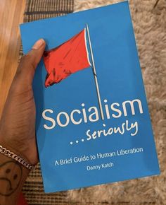 a person holding up a book with the title'socialism seriously a brief guide to human liberation '