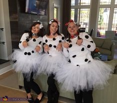 three women dressed in costumes sitting on a couch