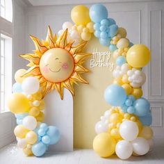 an arch made out of balloons with a happy birthday sun on the front and side