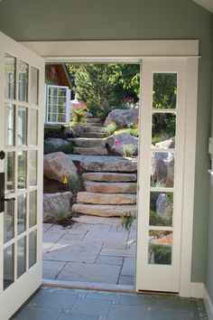 an open door leading to a stone path