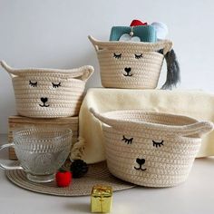 four woven baskets with animals on them and one has a cup in front of it