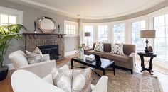 a living room filled with furniture and a fire place in front of a large window