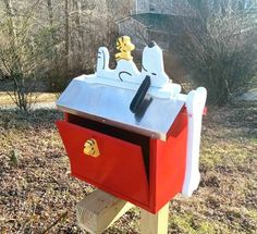 a red mailbox with snoopy figures on it