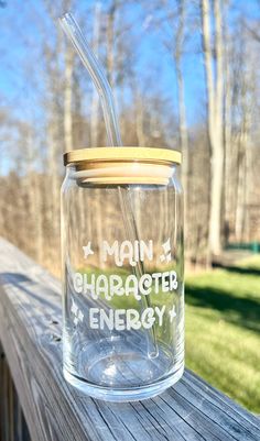 a mason jar with a straw in it sitting on a wooden fence