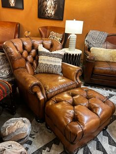 a living room filled with lots of leather furniture