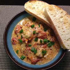 there is a bowl of soup with bread on the side