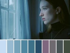 a woman is looking out the window with blue and purple colors in front of her