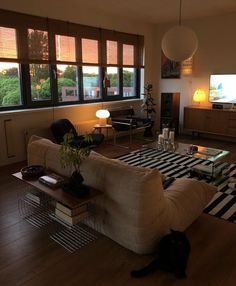 a living room filled with furniture and large windows