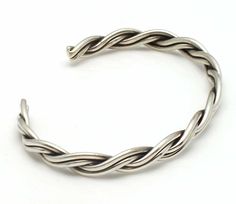 "Four round silver wires braided into a bracelet by Alene Tahe. Bracelet is 3/16"" wide and measures 5 1/8"" tip to tip with a variable opening of 1"" to 1 1/2"", fitting a wrist circumference of up to 6 3/8""." Handmade Classic Sterling Silver Braided Bracelets, Adjustable Silver Metal Braided Bracelet, Classic Silver Metal Braided Bracelet, Silver Hand-wrapped Braided Bangle Bracelet, Adjustable Sterling Silver Braided Bracelet, Nickel-free, Wire Bracelet, Silver Wire, Braids, Silver