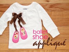 a white shirt with pink shoes on the front and brown bow at the back that says ballet shoe applique