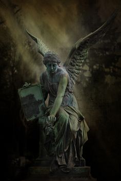 an angel statue sitting on top of a green box in the middle of a dark room