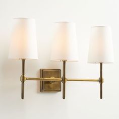 three lamps mounted on the wall next to each other with one light on it's side