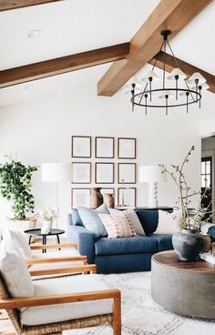 a living room with couches, chairs and pictures hanging on the wall above them