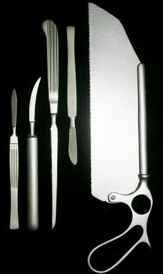 an assortment of kitchen utensils and knives on a black table top with one knife cut in half