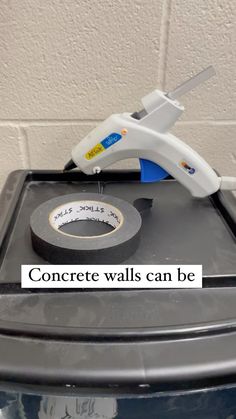 a tape dispenser sitting on top of a trash can with the words concrete walls can be removed