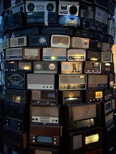 a large stack of old radio's sitting on top of each other