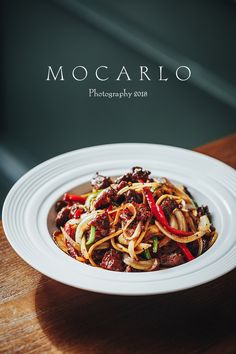 a white plate topped with pasta and meat