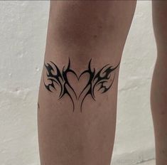 a tattoo on the leg of a woman with two birds in the shape of a heart