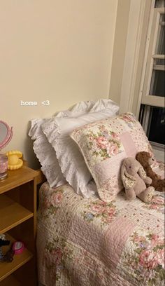 a teddy bear sitting on top of a bed next to a night stand and dresser