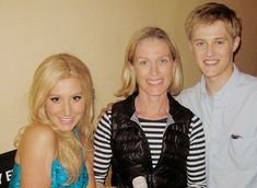 two women and a boy are posing for the camera