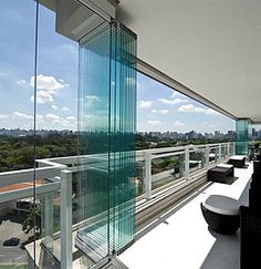 a balcony with chairs and tables overlooking the city