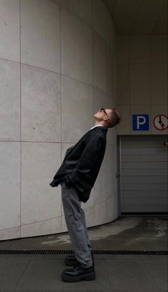 a man standing in front of a wall with his head up to the ceiling and eyes closed