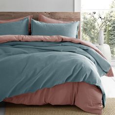 a bed with blue and pink sheets in a room