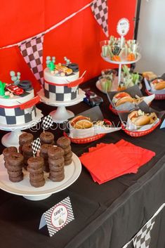 a table topped with cakes and desserts on top of tables covered in black and white checkered paper