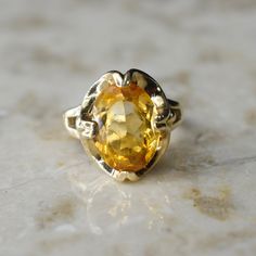 Vintage 14k gold ring with a 4.45 ct citrine stone in a retro setting. Era: c.1960s Markings: 14k Ring Size: 6 1/4 (comes with a free resizing by our jeweler) Material: 14k gold, citrine (approx. 4.45 carats) Condition: Excellent antique condition with minor surface wear from age Shipping is free in the United States Follow on Instagram @LUXXORVintage Yellow Oval Topaz Ring In 14k Gold, Formal Yellow Topaz Birthstone Ring, Oval Yellow Topaz Ring In 14k Gold, Formal Yellow Topaz Ring In 14k Gold, Vintage Yellow Gold Citrine Jewelry, Vintage Citrine Yellow Gold Jewelry, Retro Yellow Gold Ring Gift, Vintage Yellow Gold Hallmarked Topaz Ring, Vintage Yellow Gold Topaz Ring, Hallmarked