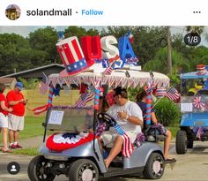 a man driving a golf cart with an american flag on it