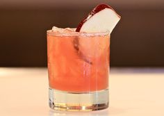 a drink with an apple slice on the rim and garnish in the middle