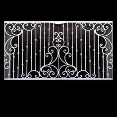 an iron gate with decorative designs on the top and bottom, against a black background