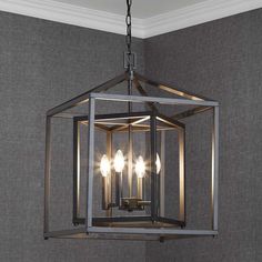 a chandelier hanging from the ceiling in a room with grey walls and carpet