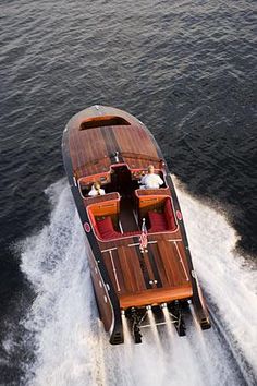 a motor boat with people riding on it's back in the water