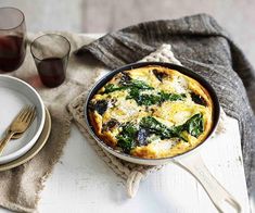 an omelet with spinach and cheese in a skillet on a table