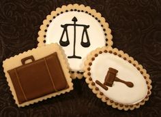 three cookies decorated like law and briefcases on a brown tablecloth with chocolate accents